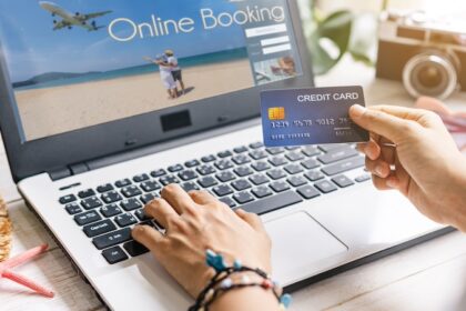 Young women planning summer vacation trip and searching information or booking hotel and using credit card on laptop, Travel concept