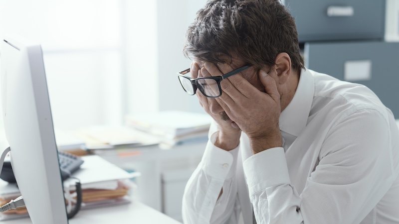 Tired stressed businessman rubbing his eyes