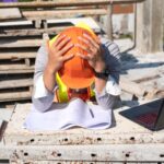 Stress engineer or architect with laptop and tablet holding hands at his head. He is having problems in work. Engineering concept.